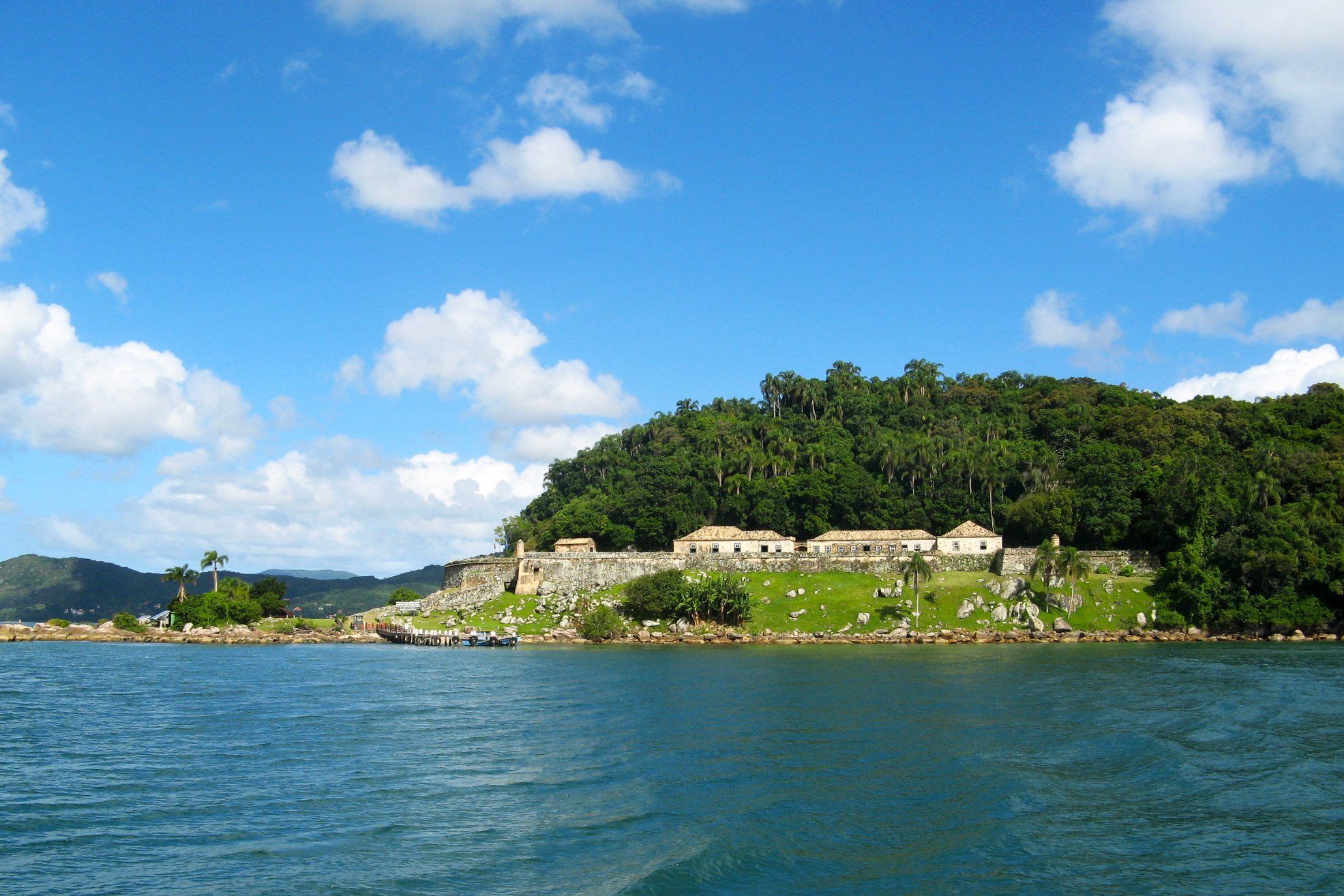 A Ilha de Ratones Grande com a fortaleza entre a mata, vista do mar
